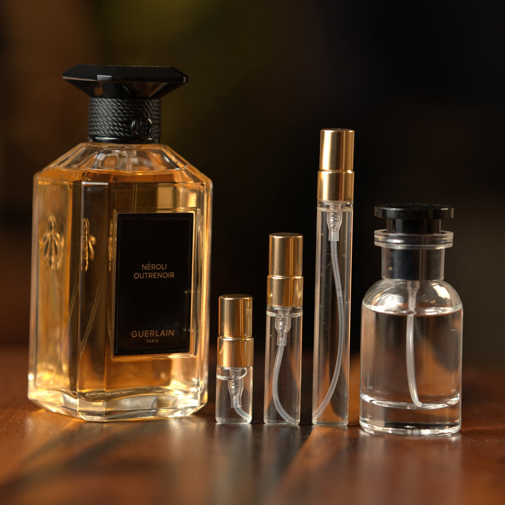 Guerlain Néroli Outrenoir eau de parfum beside Atelier Elemental decant vials in 2 ml, 5 ml, 10 ml and 30 ml sizes