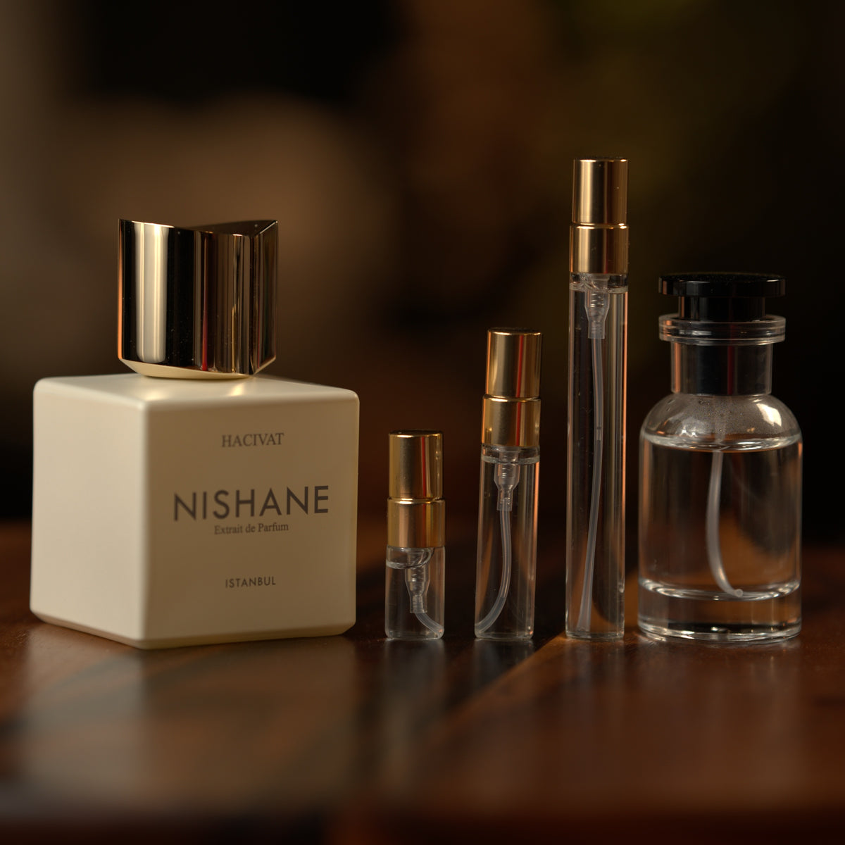 Nishane Hacivat extrait de parfum beside Atelier Elemental decant vials in 2 ml, 5 ml, 10 ml and 30 ml sizes