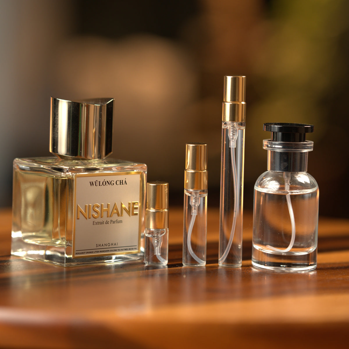 Nishane Wulóng Chá extrait de parfum beside Atelier Elemental decant vials in 2 ml, 5 ml, 10 ml and 30 ml sizes