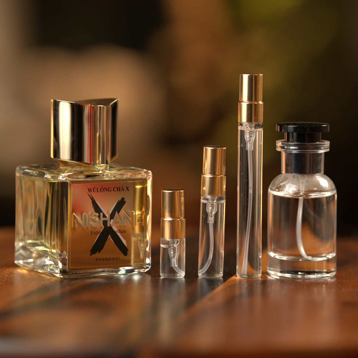 Nishane Wulóng Chá X extrait de parfum beside Atelier Elemental decant vials in 2 ml, 5 ml, 10 ml and 30 ml sizes