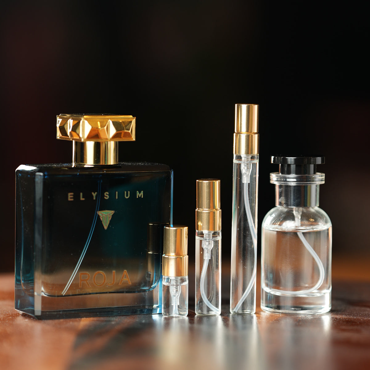 Roja Parfums Elysium Pour Homme Eau de Parfum bottle beside Atelier Elemental decant vials